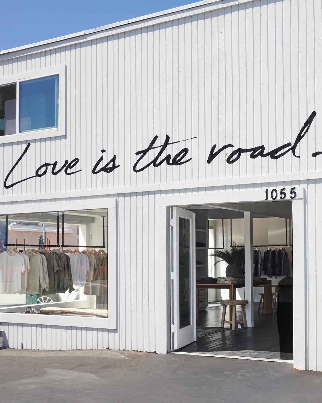 Store front with open door and "Love is the road" painted on wall