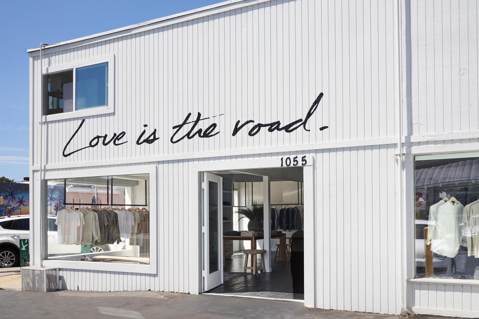 Store front with open door and "Love is the road" painted on wall