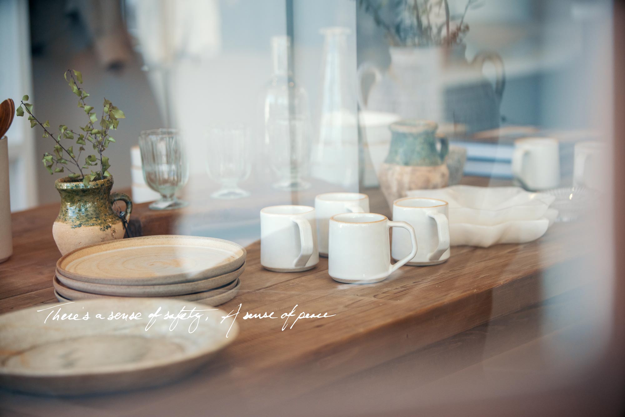 Table with mugs and plates seen through window