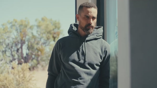 Video of man wearing hooded sweatshirt in desert house