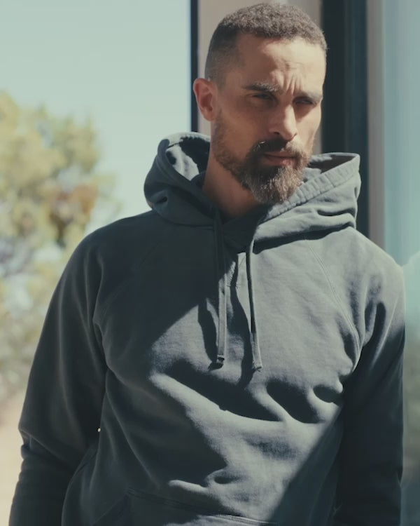 Video of man wearing hooded sweatshirt in desert house
